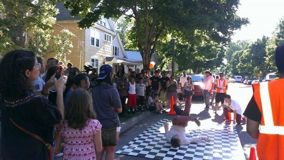 Neighbors celebrate outside of a house moved to Frogtown