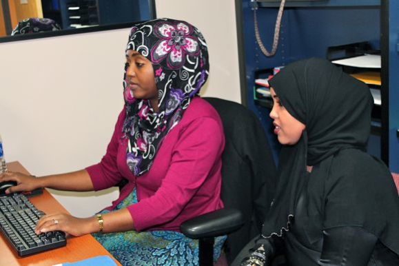 Ayan Hussein, employment and financial coach, with a resident